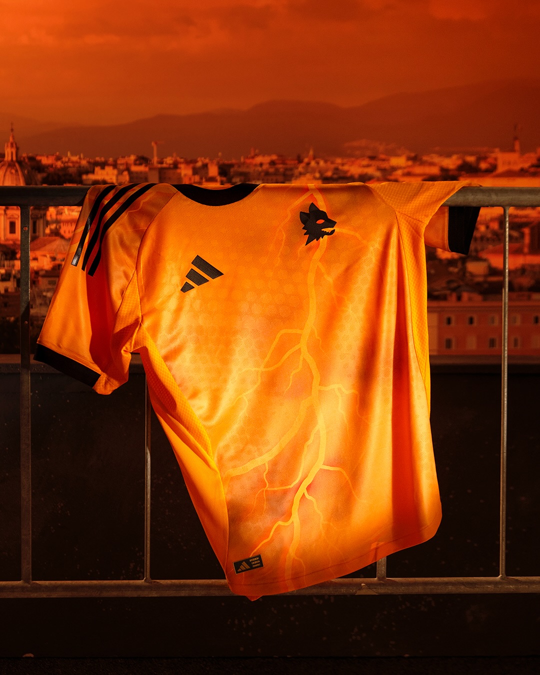 Maglia away dell'AS Roma 2025-2026: arancione con i fulmini di Marte