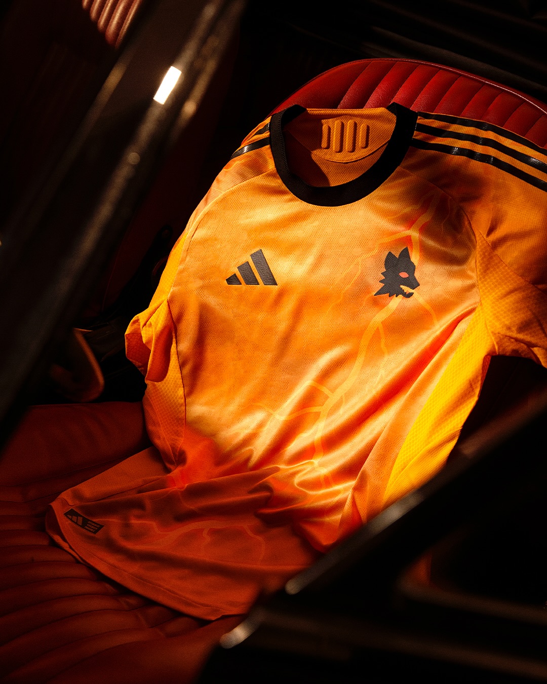 Maglia away dell'AS Roma 2025-2026: arancione con i fulmini di Marte